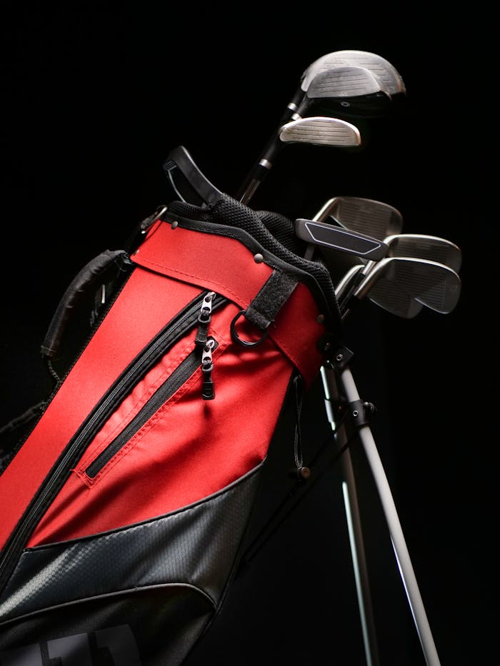 Red and black golf bag with full set of clubs for professional golfing needs.